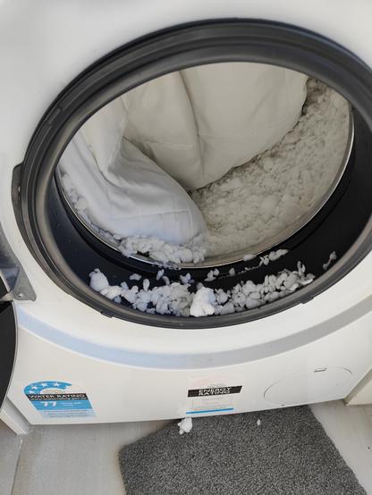 Looking into a front loading washing machine filled with quite well wrung out foam bits and the pillow case which previously contained them. Oh noes! 